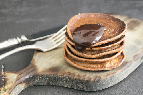 Chocolate pancakes with chocolate sauce on a dark background.