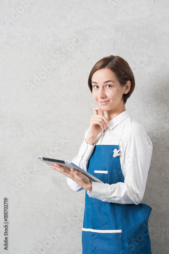 エプロン姿でタブレットPCを持つ女性