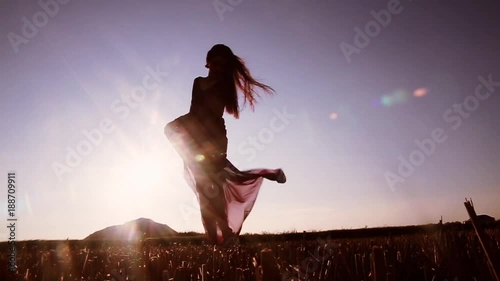beautiful woman in a transparent dress dancing at sunset