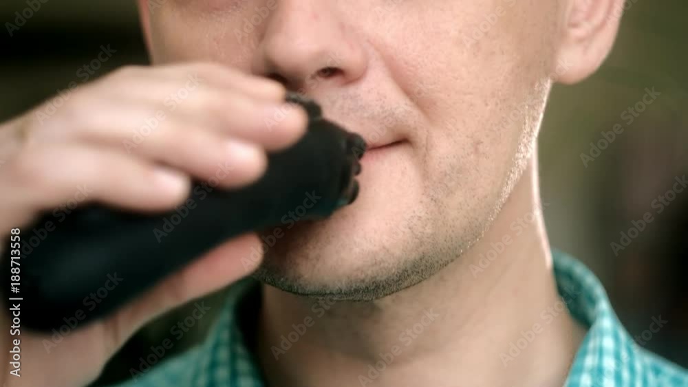 Man shaving beard with electric shaver. Check shaving swiping your finger on the cheek. Closeup. Man shaving beard with electric shaver. Check shaving swiping your finger on the cheek. Closeup.