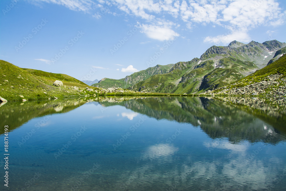 
A beautiful mountain lake. Mountain valley. Green glade. Mountain flowers. Summer. Caucasus.