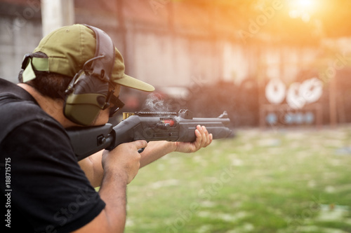 Man shooting on an outdoor shooting range, selective focus photo