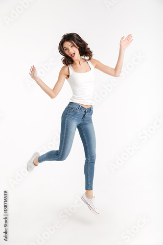 Full length portrait of an excited girl dressed in tank-top