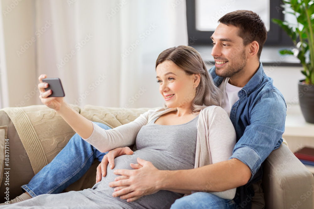 man and pregnant woman taking selfie at home man and pregnant woman taking selfie at home