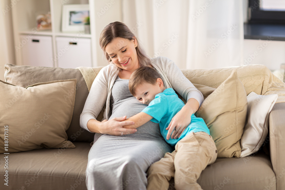 happy pregnant mother and son hugging at home