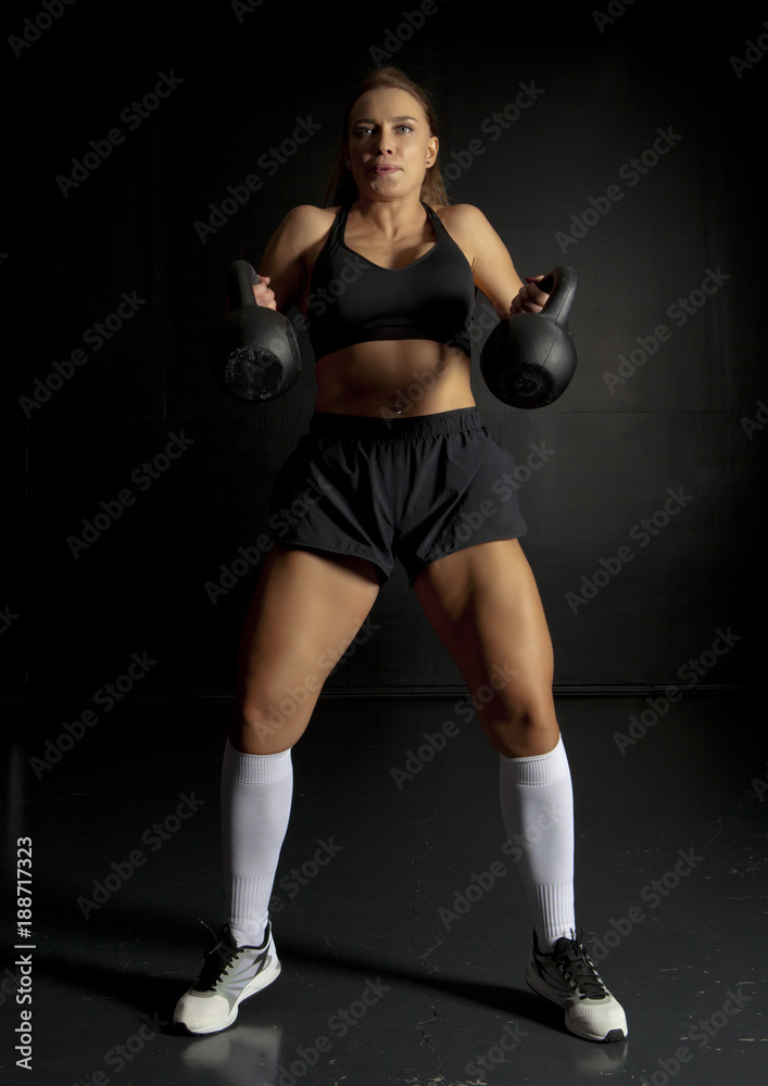 Woman doing her kettlebell exercise Woman doing her kettlebell exercise