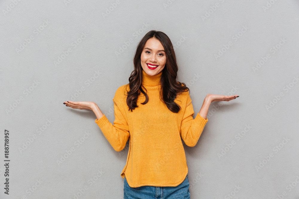 Happy woman in sweater choosing something and looking at camera Happy woman in sweater choosing something and looking at camera