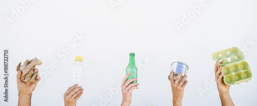 Human hands showing recyclable paper, plastic, glass and aluminum can