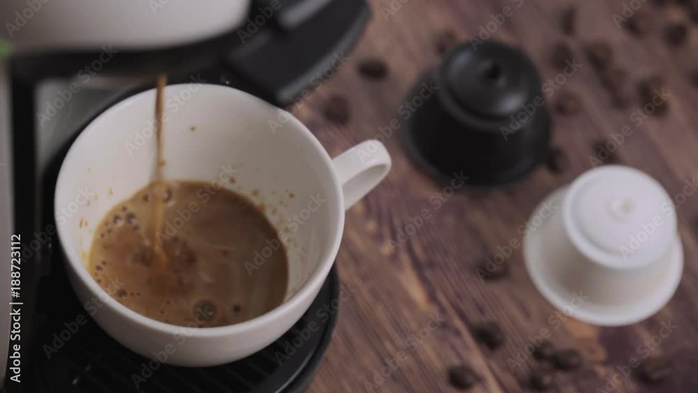 Coffee pouring cup and capsules on a rustic wooden table Coffee pouring cup and capsules on a rustic wooden table
