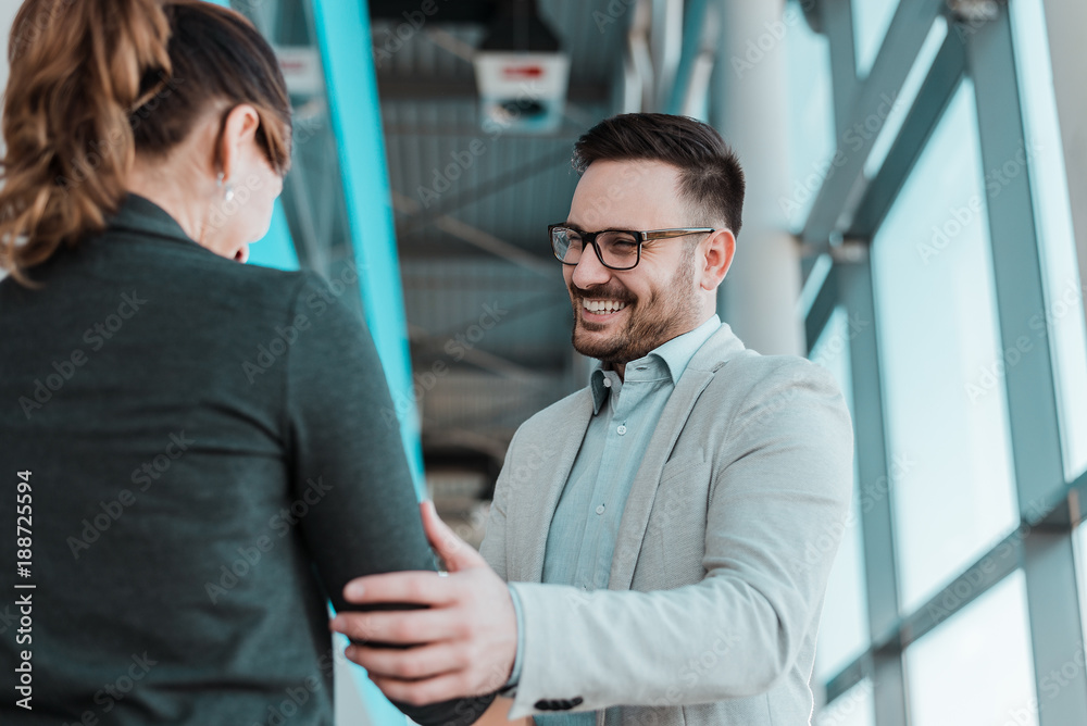 Associates handshaking after striking deal. Smiling businessman and businesswoman handshake. Associates handshaking after striking deal. Smiling businessman and businesswoman handshake.