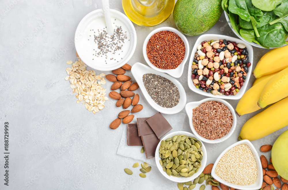 Healthy food nutrition dieting concept. Banana, chocolate, spinach, avocado, apple, quinoa, chia, flax seeds, yogurt, almond, beans, oat, pumpkin seeds, olive oil. Top view, flat lay, copy space. - obrazy, fototapety, plakaty 