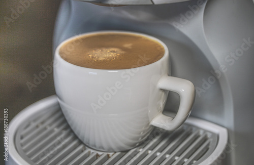 A cup of espresso in a coffee-machine. Close-up