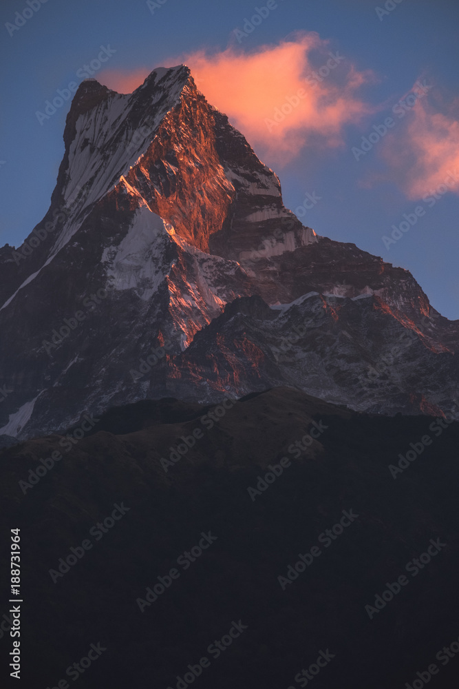 Fototapeta premium Rugged peak with some clouds glowing at sunrise