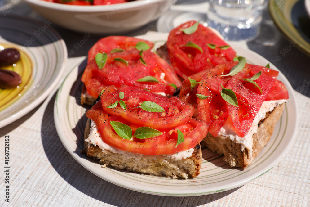 Sandwiches with feta cheese, fresh tomatoes, basil leaves as an appertizer.