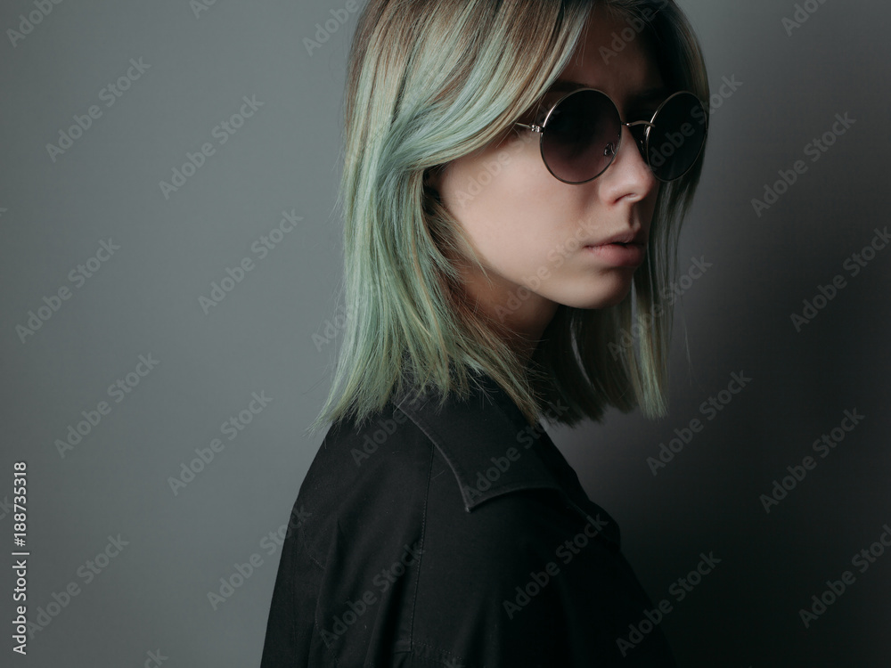 Young woman with suglasses on grey background. Studio portrait Young woman with suglasses on grey background. Studio portrait