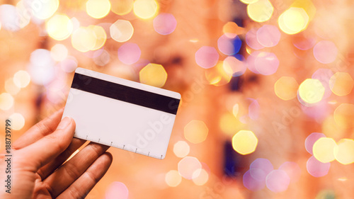 card for payment. bokeh. hand holds a card