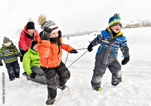 Child boy Pulling Sledge Through Snowy Landscape