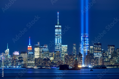 The two beams of the Tribute in Light with skycrapers of Financial District at night. Lower Manhattan, New York City