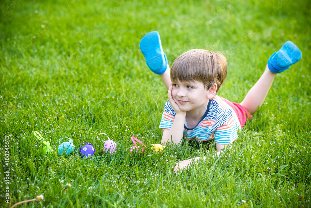 Little boy hunting for easter egg in spring garden on Easter day. Cute little child with traditional bunny celebrating feast Little boy hunting for easter egg in spring garden on Easter day. Cute little child with traditional bunny celebrating feast