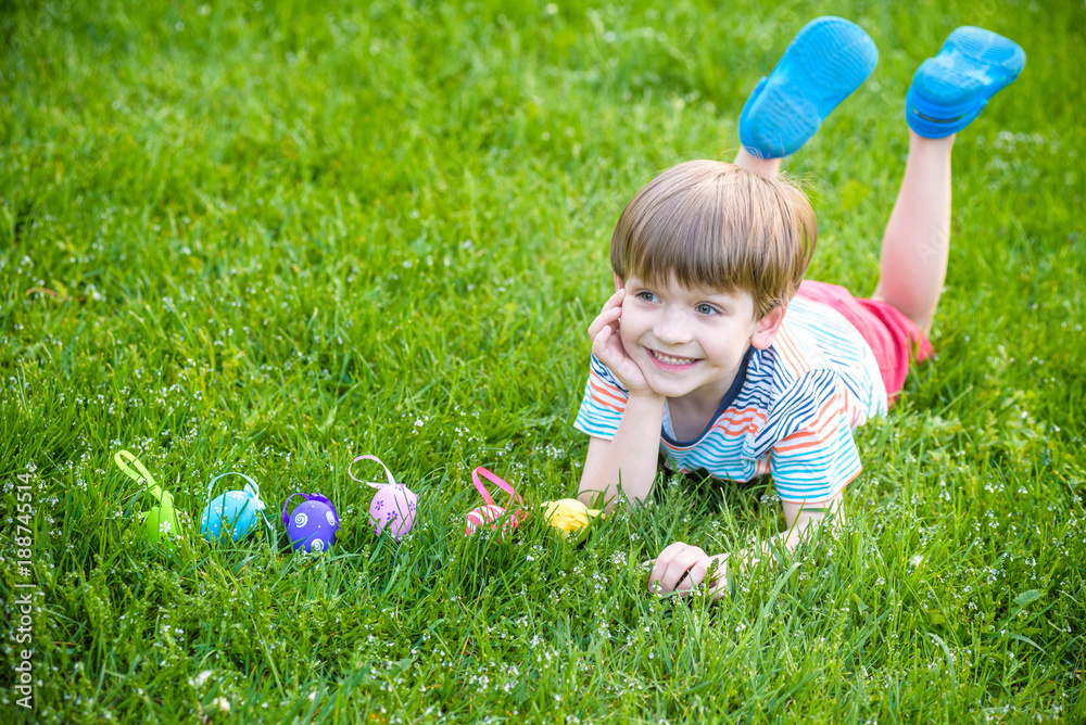Little boy hunting for easter egg in spring garden on Easter day. Cute little child with traditional bunny celebrating feast Little boy hunting for easter egg in spring garden on Easter day. Cute little child with traditional bunny celebrating feast