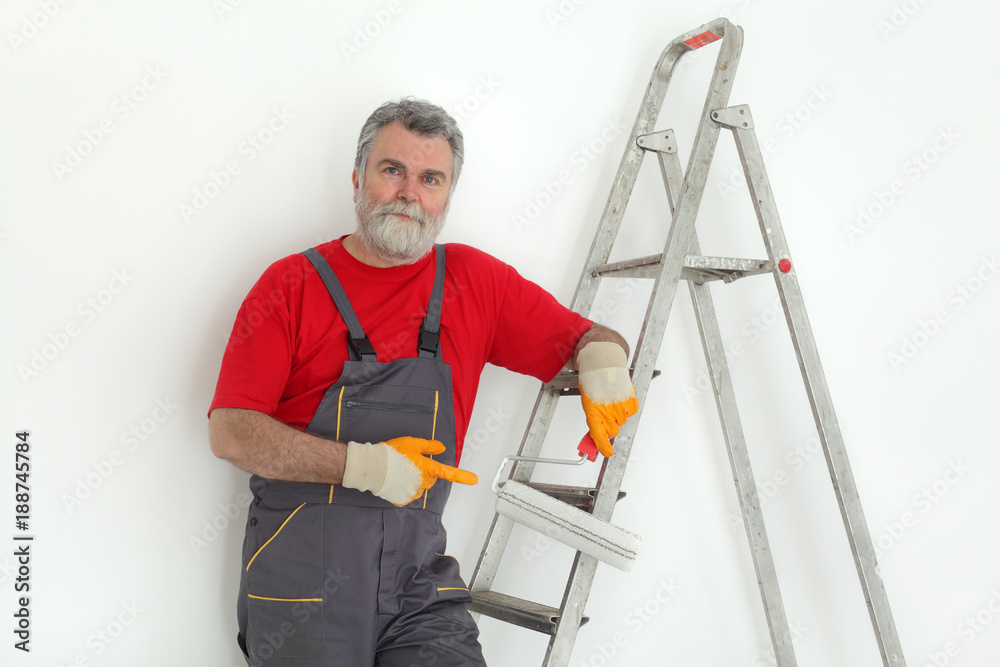 Worker painting wall to white and gesturing, with ladder and paint roller Worker painting wall to white and gesturing, with ladder and paint roller