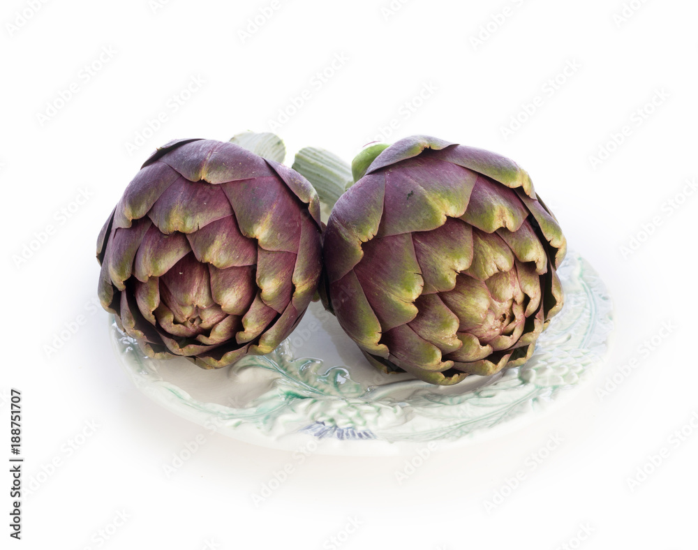 Obraz premium Two purple artichokes ready to cook on old plate