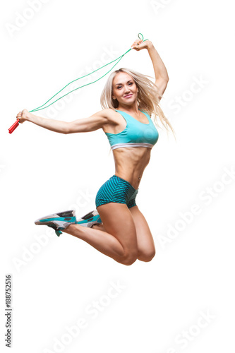 Full length image of a young sports woman jumping on skipping rope over white background photo