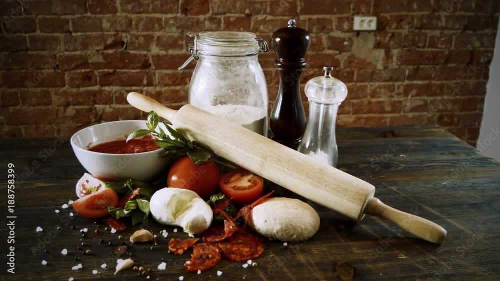 Close-up shot of ingredients for preparing a pizza on wooden table. 4K Close-up shot of ingredients for preparing a pizza on wooden table. 4K