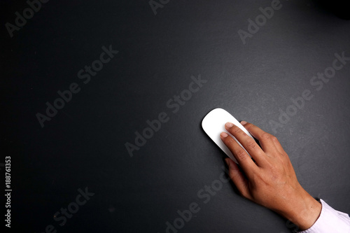 Man holds a white mouse over a black background.