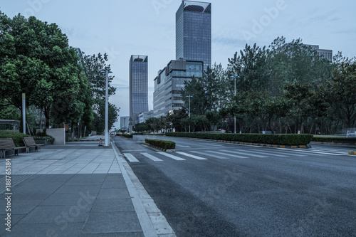 empty asphalt road near glass office building.