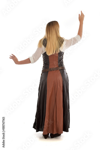 full length portrait of girl wearing brown fantasy costume.. standing pose with back to the camera on white studio background. 
