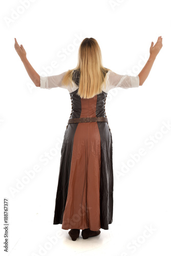 full length portrait of girl wearing brown fantasy costume.. standing pose with back to the camera on white studio background. 