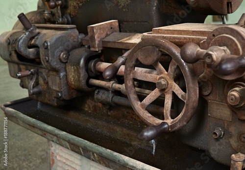 Grain Image: Close up of old machine factory made of steel and used in the past. Broken and rustic machine left over in abandon factory. Image of aged equipment with rust and gear part.