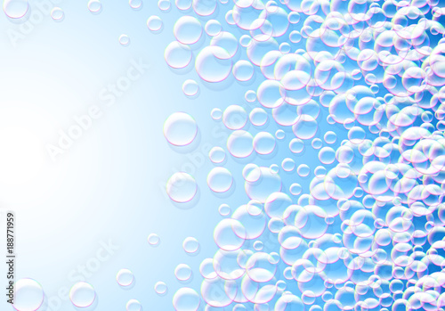 Soap bubbles abstract blue background with rainbow colored airy foam