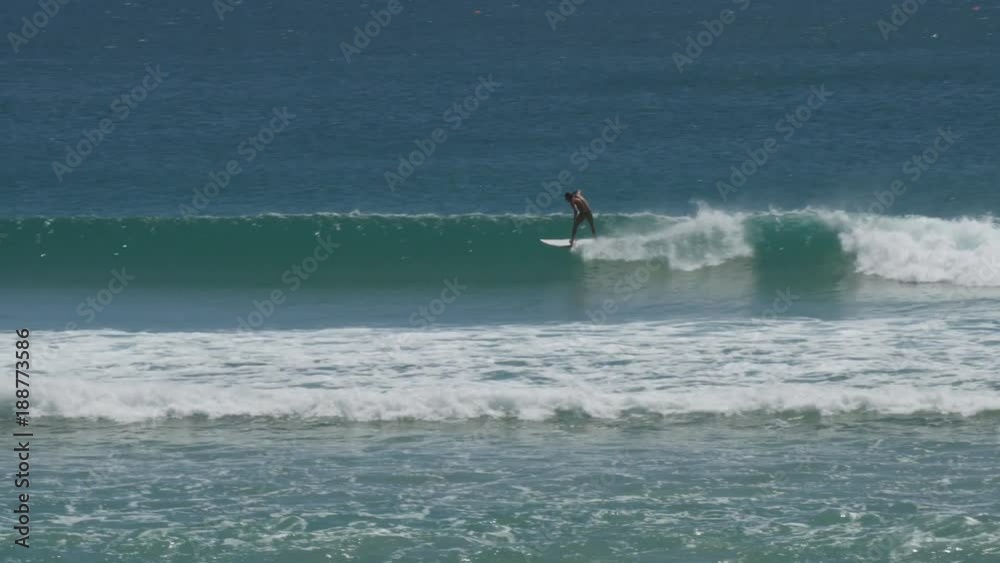 tracking shot of a young man surfing the famous wave at kirra on the gold coast of queensland, australia tracking shot of a young man surfing the famous wave at kirra on the gold coast of queensland, australia
