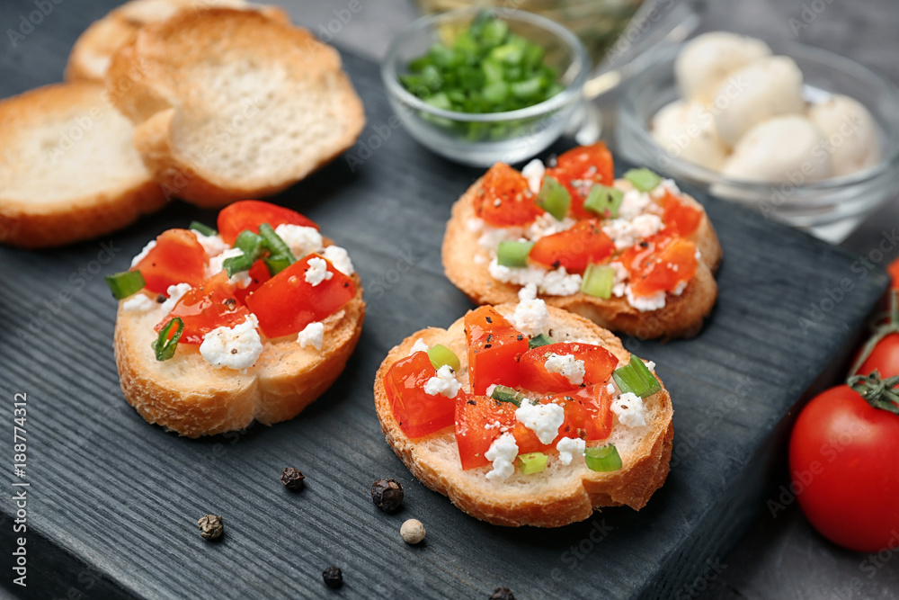 Tasty bruschettas with tomatoes on wooden board, closeup Tasty bruschettas with tomatoes on wooden board, closeup