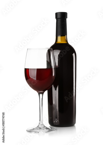 Bottle and glass with red wine on light background