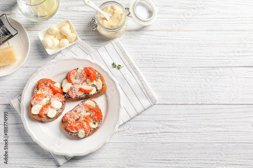Tasty bruschettas with cherry tomatoes and cheese on plate