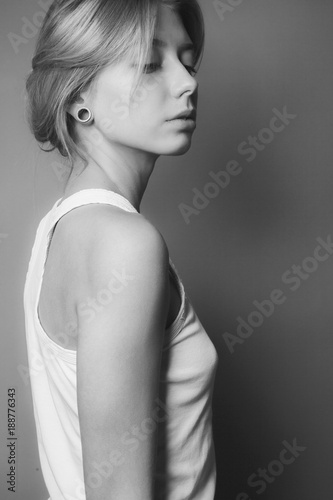 Gentle cute young woman. Studio portrait. Side view. Black and white