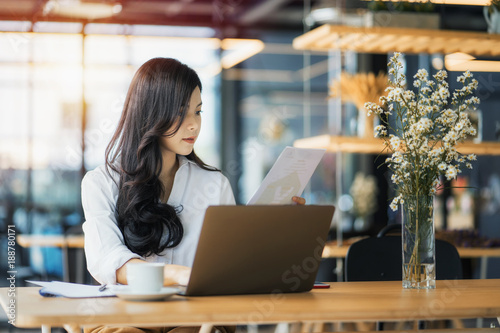 Young business woman using on the laptop while sitting at her working place. 