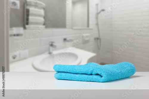 Bright colored towel on a shelf  in a bathroom