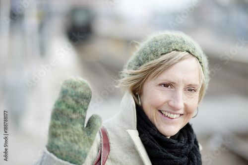 Portrait of adult woman raising hand and smiling