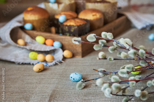 Spring Easter photo. Sprigs of pussy willows  pasques  cakes  colorful eggs. Background and space for your text.