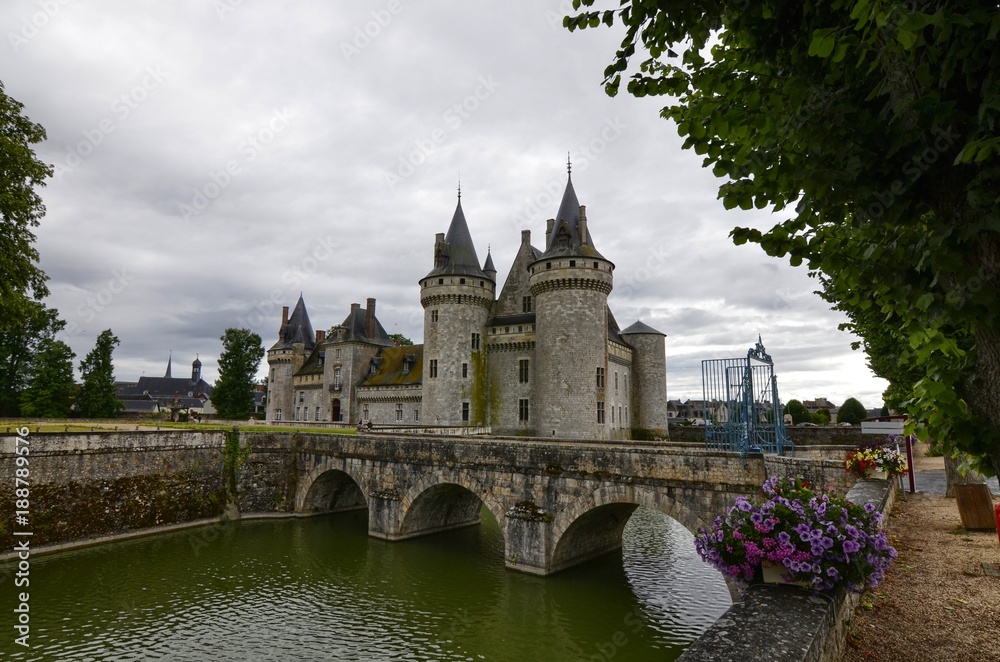 Fototapeta premium Castle of Sully-sur-Loire, Loire region, France. Snap of 30 June 2017 at 18:21. Captured at the entrance of the castle park. White clouds moving on blue sky. Towers well visible in the image.