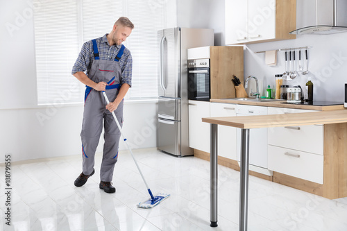 Young Male Worker Mopping Floor