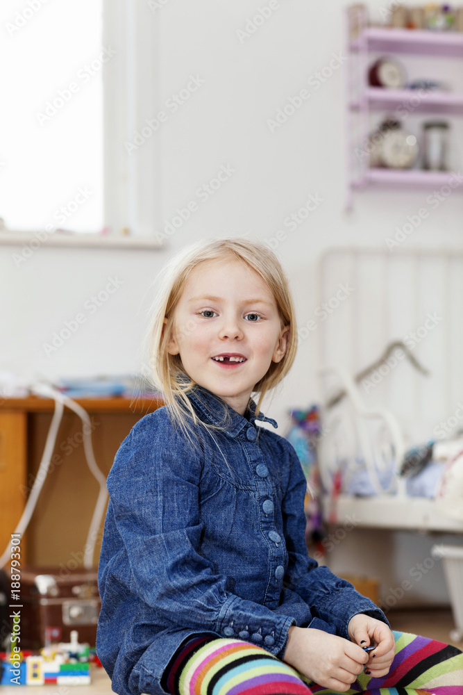 Young girl sitting on floor smiling at camera Young girl sitting on floor smiling at camera