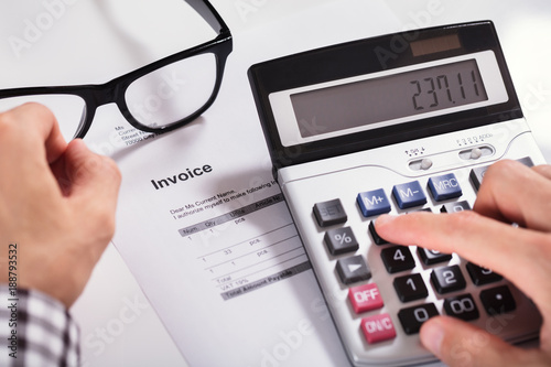 Businessman's Hands Calculating Invoice