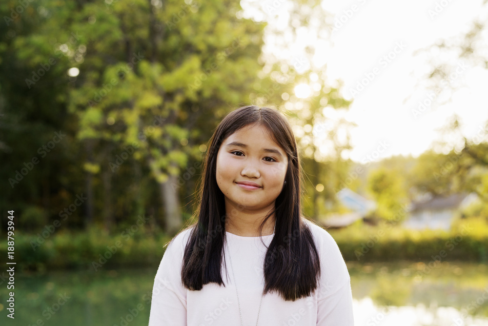 Portrait of smiling girl with straight black hairåÊstanding outdoors Portrait of smiling girl with straight black hairåÊstanding outdoors