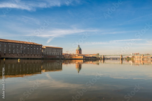 Hospital de La Grave on a sunny day reflected in Garone river. Toulouse, France