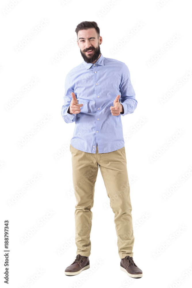 Happy friendly bearded man winking and pointing fingers at camera. Full body length portrait isolated on white studio background. Happy friendly bearded man winking and pointing fingers at camera. Full body length portrait isolated on white studio background.